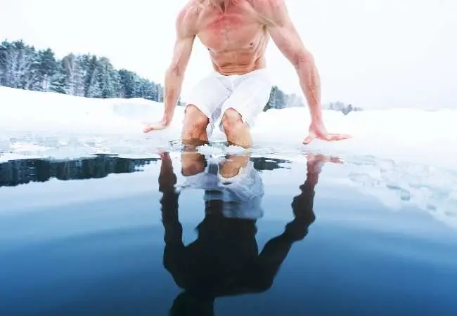 uomo a petto nudo si immerge in acqua ghiacciata
