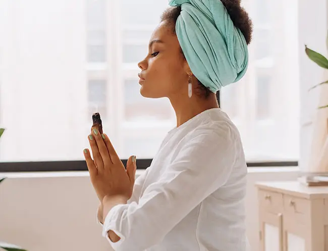 donna di colore medita con un cristallo tra le mani