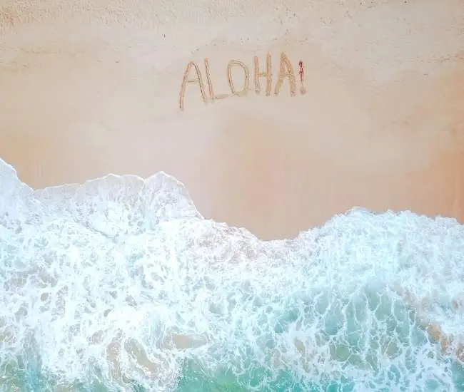 scritta aloha sulla sabbia