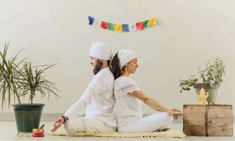 due persone praticano la meditazione tantrica schiena a schiena