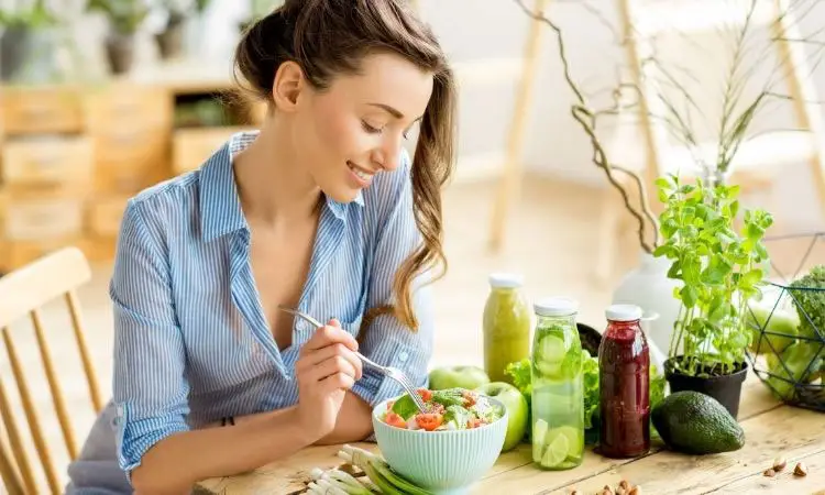 donna mangia un piatto di insalata