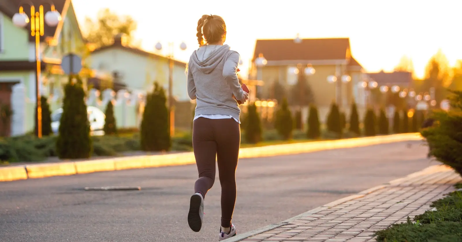 donna fa jogging su una strada di periferia