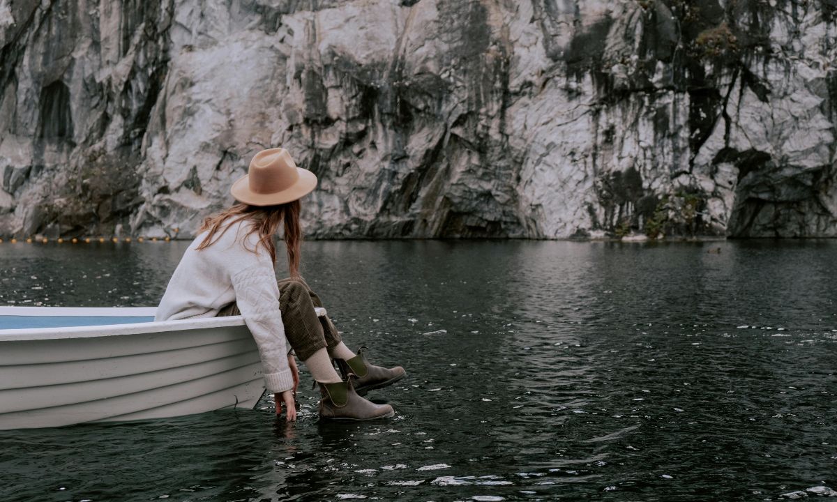donna su una barca guarda l'acqua di un lago