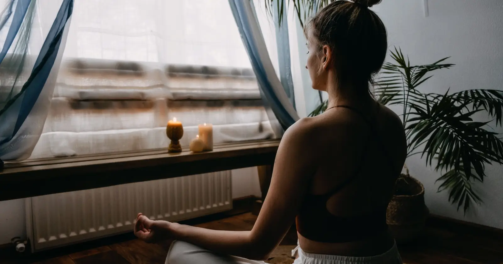donna medita a casa davanti a una finestra