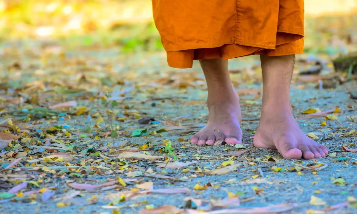 i piedi di un monaco scalzo che cammina